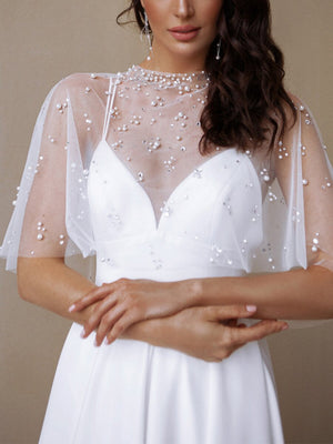 Elegante vestido largo de tirantes blancos con mantón de perlas